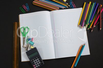 Various school supplies on black background