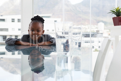 Portrait of smiling businesswoman with reflection leaning on table