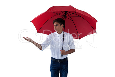 Boy standing under a red umbrella