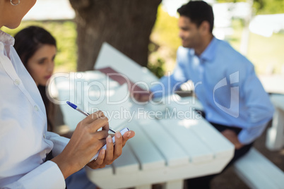 Waitress writing order on notepad