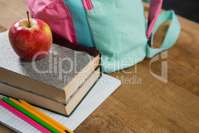 Apple on stack of books with schoolbag