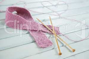 Close-up of woolen Breast Cancer Awareness ribbon with needles and heart shape