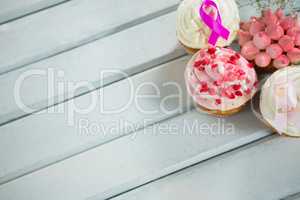 High angle view of Breast Cancer Awareness pink ribbons on cupcakes