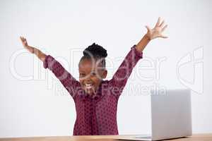 Portrait of cheerful woman with arms raised by laptop
