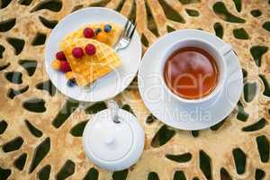 Cup of tea with dessert on table