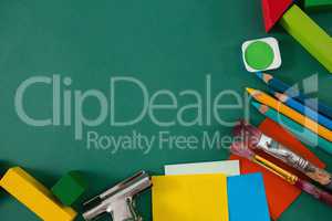 Various school supplies on green background