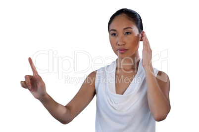 Serous businesswoman pretending to answer call while touching invisible interface