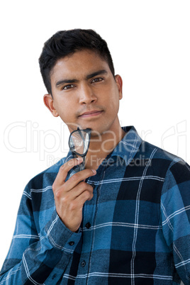 Portrait of young man holding eyeglasses