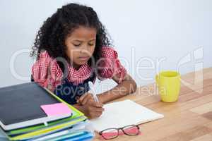 Girl imitating as businesswoman writing on book