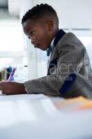 Businessman writing on document at desk