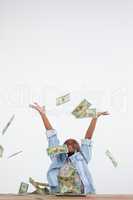 Cheerful businesswoman throwing paper currency in mid-air