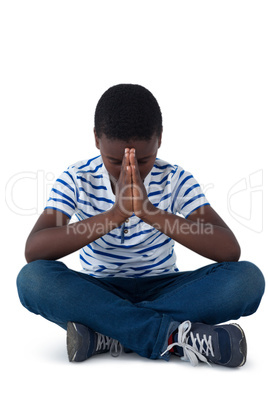 Boy sitting on floor and praying