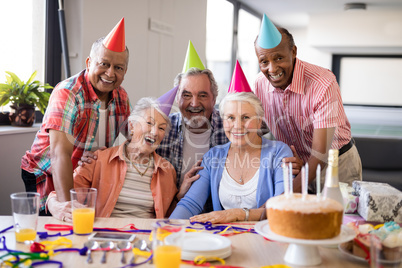 Portrait of senior people wearing party hats celebrating birthday