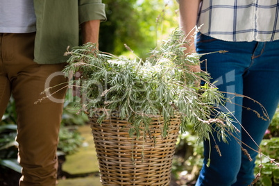 Mid-section of couple walking with flower basket