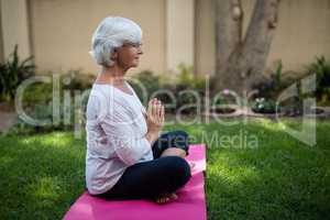 Side view of senior woman meditating in prayer position