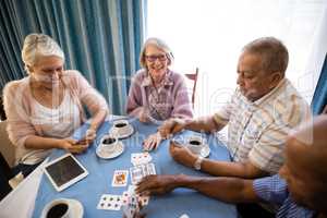 High angle view of senior friends playing cards