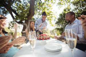 Group of friends celebrating womans birthday at outdoor restaurant