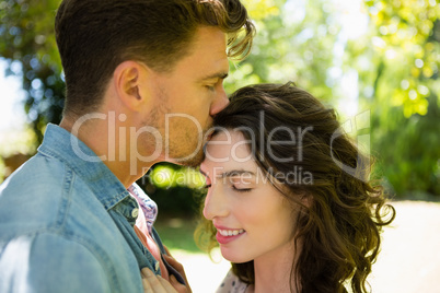 Man kissing woman on forehead