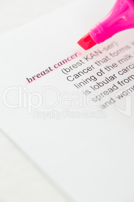 Cropped image of pink felt tip pen with Breast Cancer text on paper
