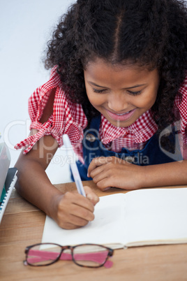 High angle view of smiling businesswoman writing on book