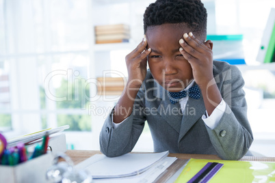 Boy as businessman with head in hand