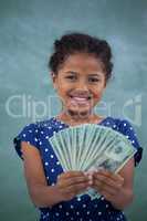 Close up portrait of smiling girl showing paper currency