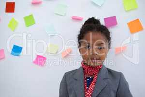 Portrait of businesswoman standing  against sticky notes on wall