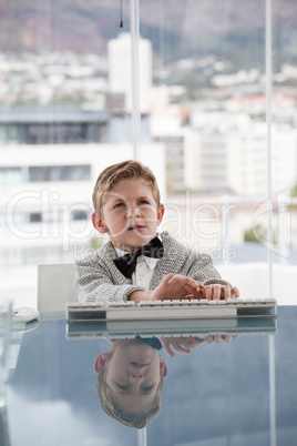 Serious businessman typing on keyboard at table