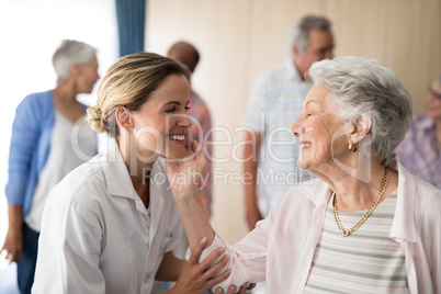 Senior woman touching smiling female doctor