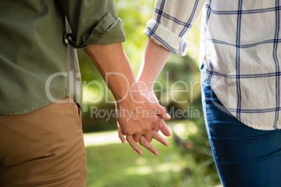 Mid-section of couple holding hands