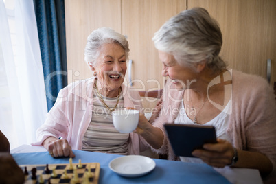 Happy senior friends talking while having coffee