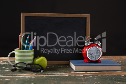 Chalkboard with book, pen holder, apple and spectacles