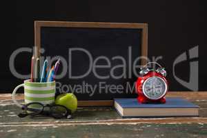 Chalkboard with book, pen holder, apple and spectacles