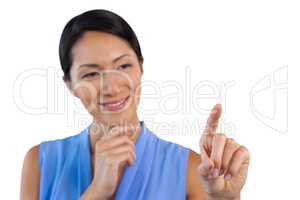Smiling businesswoman with hand on chin touching interface