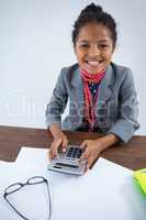 Portrait of smiling girl pretending as businesswoman using calculator
