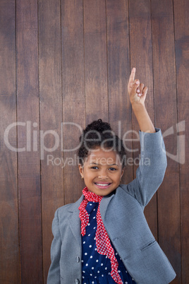 Portrait of smiling girl pretending as businesswoman standing with arms raised