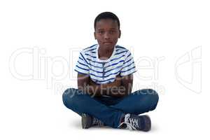 Portrait of sad boy sitting on floor
