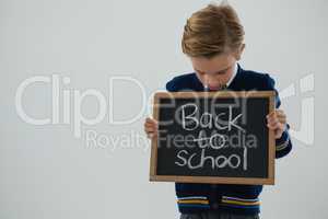 Schoolboy holding slate with text against white background