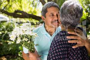 Senior man giving flowers to woman