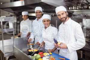 Chefs chopping vegetables on chopping board in the commercial kitchen