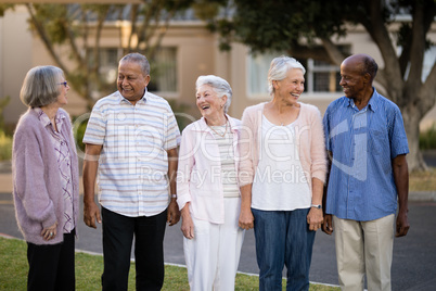 Cheerful seniors standing while looking at each other