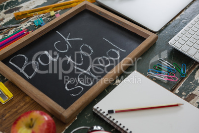 Text written on slate with school supplies