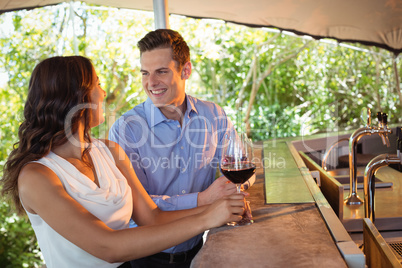 Couple having a glass of red wine at counter