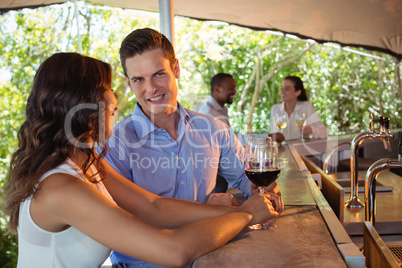 Couple having a glass of red wine at counter