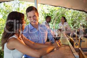 Couple having a glass of red wine at counter