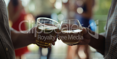 Male friends toasting cocktail glasses in restaurant