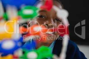 Schoolgirl experimenting molecule model against black background