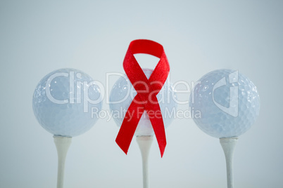 Close-up of red AIDS Awareness ribbon on golf ball