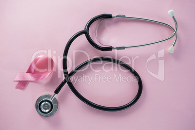 Overhead view of stethoscope by Breast Cancer Awareness ribbon