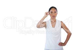 Businesswoman looking away while adjusting invisible eyeglasses